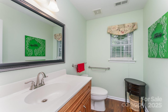 10322 Stoneykirk Ln, Charlotte, NC 28269 - bathroom featuring wood finished floors, vanity, toilet, and baseboards