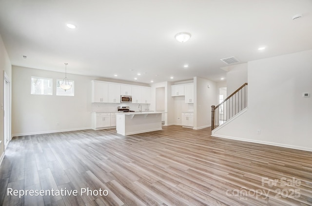 2233 Tabor Rd Unit 586, Sherrills Ford, NC 28673 - unfurnished living room featuring light wood-style flooring, recessed lighting, baseboards, stairway, and a sink