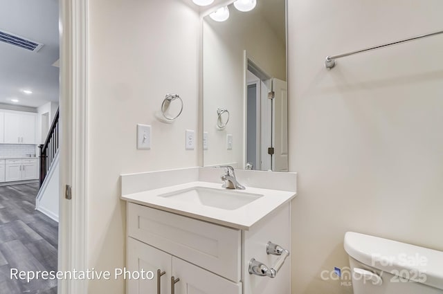 2233 Tabor Rd Unit 586, Sherrills Ford, NC 28673 - bathroom featuring toilet, vanity, tasteful backsplash, and wood finished floors