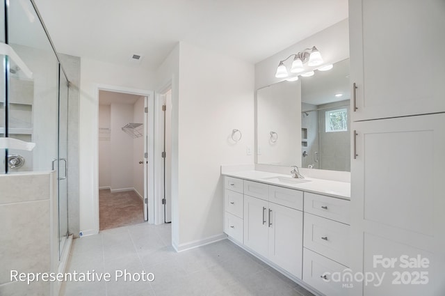 2233 Tabor Rd Unit 586, Sherrills Ford, NC 28673 - bathroom with a shower stall, a walk in closet, vanity, baseboards, and tile patterned floors