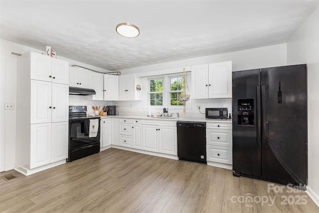 875 Marys Grove Rd, Cherryville, NC 28021 - kitchen with black appliances, under cabinet range hood, a sink, and light wood-style floors