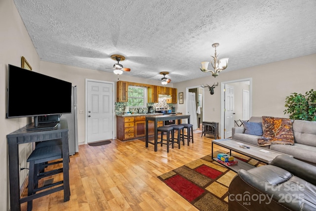 79 Jeffrey Ln, Waynesville, NC 28785 - living area featuring light wood finished floors, a chandelier, ceiling fan, a textured ceiling, and baseboards