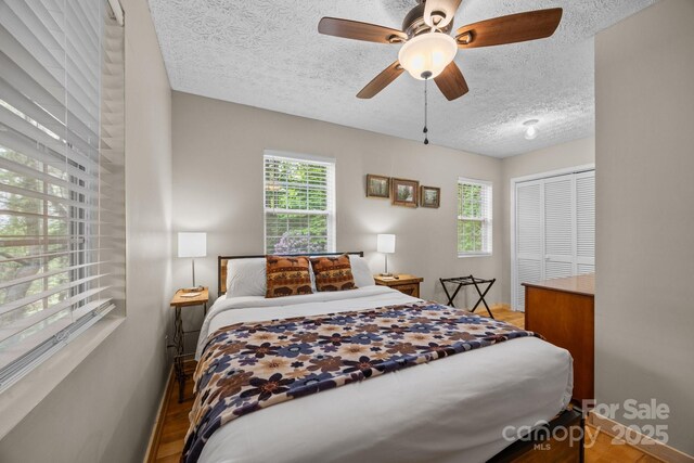 79 Jeffrey Ln, Waynesville, NC 28785 - bedroom featuring a textured ceiling, baseboards, light wood-type flooring, a ceiling fan, and a closet
