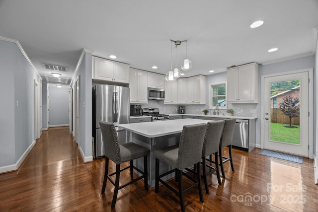4106 Castlewood Rd, Charlotte, NC 28209 - kitchen with stainless steel appliances, backsplash, a center island, white cabinetry, and dark wood-style floors