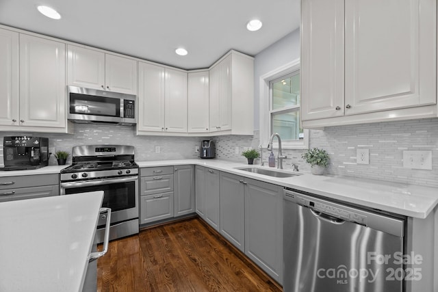 4106 Castlewood Rd, Charlotte, NC 28209 - kitchen featuring stainless steel appliances, gray cabinetry, a sink, dark wood-type flooring, and light countertops