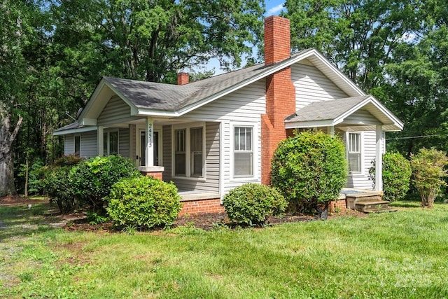 24515 Saint Martin Rd, Albemarle, NC 28001 - view of front of property with a chimney, a front yard, covered porch, and roof with shingles