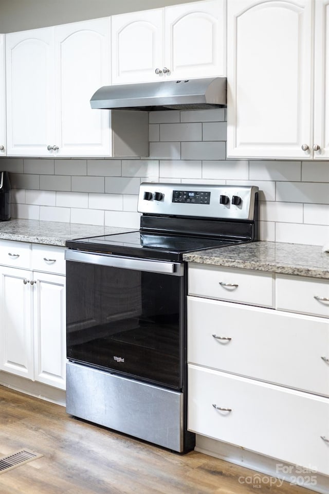 3716 Hamilton Dr, Gastonia, NC 28052 - kitchen featuring electric stove, under cabinet range hood, white cabinetry, and backsplash