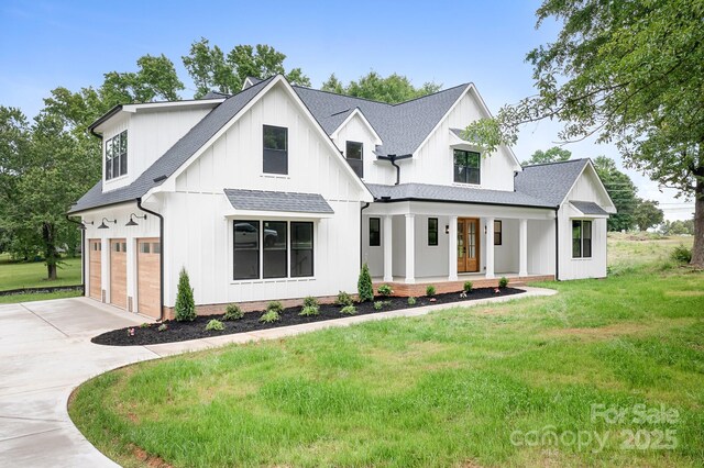 104 Arbor Dr, Waxhaw, NC 28173 - modern farmhouse featuring a porch, driveway, a front yard, and board and batten siding