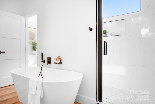 104 Arbor Dr, Waxhaw, NC 28173 - bathroom featuring a freestanding tub, a stall shower, and wood finished floors