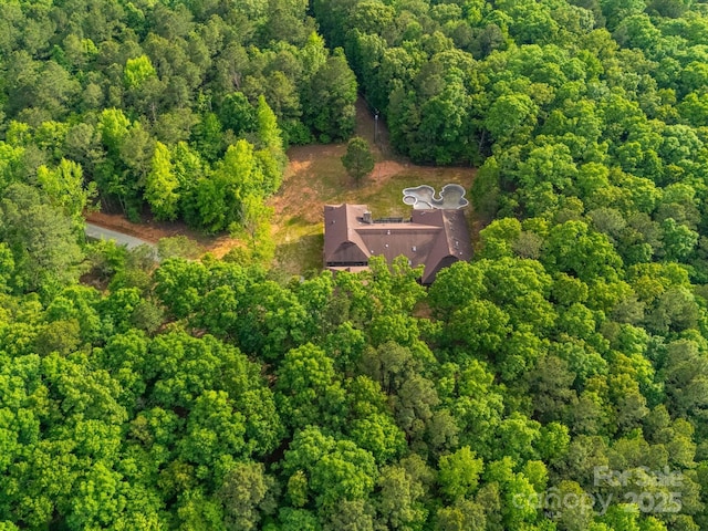 view of subject property with a heavily wooded area