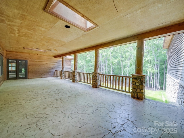 additional living space featuring stone floors, wood ceiling, and wooden walls