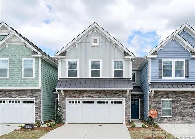 7416 Hartsfield Dr, Lancaster, SC 29720 - craftsman-style home with concrete driveway, stone siding, an attached garage, board and batten siding, and a standing seam roof