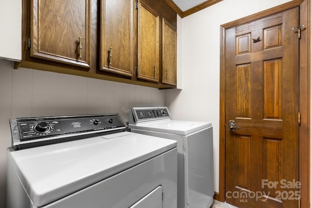 laundry area with cabinet space, washer and dryer, and ornamental molding