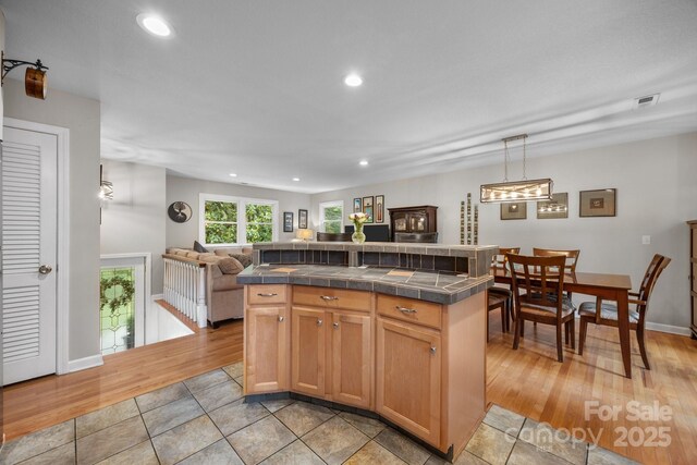 931 Indian Hill Rd, Hendersonville, NC 28791 - kitchen featuring tile counters, recessed lighting, open floor plan, light wood-style flooring, and decorative light fixtures