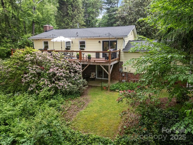 931 Indian Hill Rd, Hendersonville, NC 28791 - back of house with a deck, a chimney, a shingled roof, brick siding, and a lawn