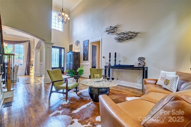 5826 Natoma Rd, Lake Wylie, SC 29710 - living room with ornamental molding, wood finished floors, ornate columns, a chandelier, and a high ceiling