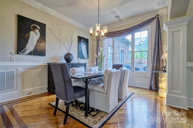 5826 Natoma Rd, Lake Wylie, SC 29710 - dining room featuring a chandelier, wood finished floors, ornamental molding, and a decorative wall