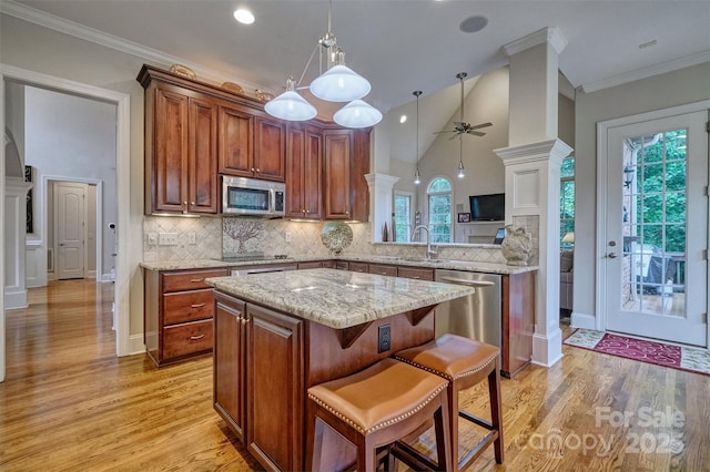 5826 Natoma Rd, Lake Wylie, SC 29710 - kitchen with stainless steel appliances, a center island, decorative backsplash, light wood finished floors, and ceiling fan