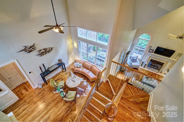 5826 Natoma Rd, Lake Wylie, SC 29710 - living room with ceiling fan, wood finished floors, a towering ceiling, and a high end fireplace