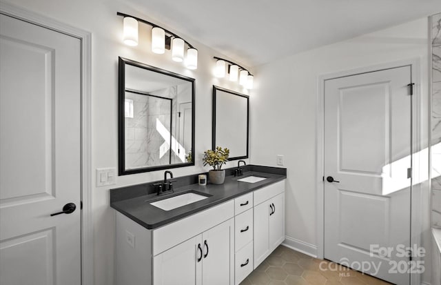bathroom featuring double vanity, baseboards, tile patterned floors, and a shower