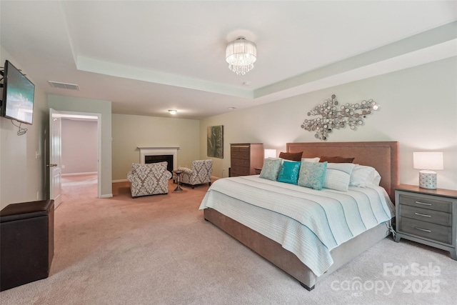 5812 Dinsmore Ln, Belmont, NC 28012 - bedroom with a raised ceiling, light carpet, a fireplace, and a chandelier