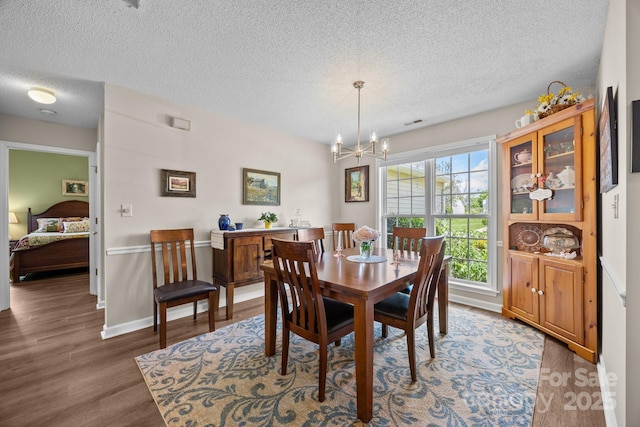 296 Planters Creek Rd, Fletcher, NC 28732 - dining space with a textured ceiling, a chandelier, wood finished floors, and baseboards