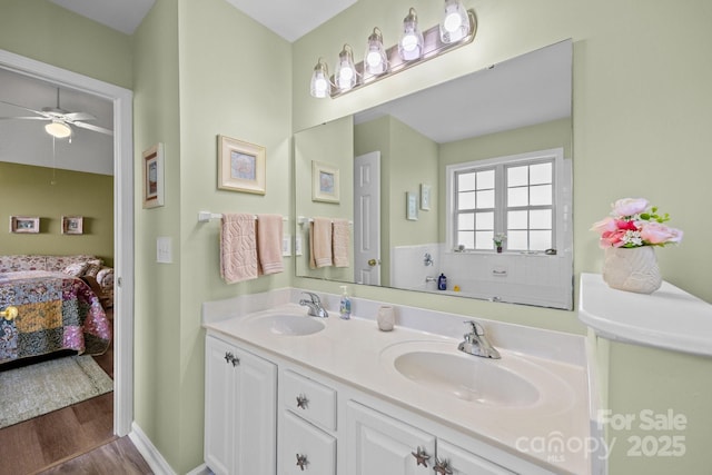 296 Planters Creek Rd, Fletcher, NC 28732 - bathroom with connected bathroom, wood finished floors, ceiling fan, double vanity, and baseboards
