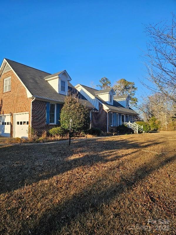 100 Boros Lndg, New Bern, NC 28560 - view of property exterior featuring brick siding, a garage, and a lawn