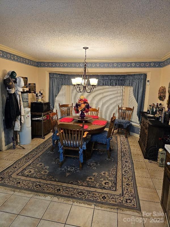 100 Boros Lndg, New Bern, NC 28560 - dining space featuring a textured ceiling, a chandelier, crown molding, and tile patterned flooring