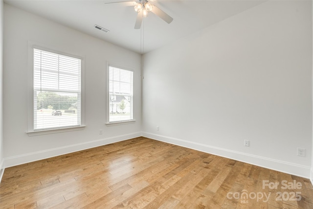 spare room featuring baseboards, ceiling fan, and wood finished floors