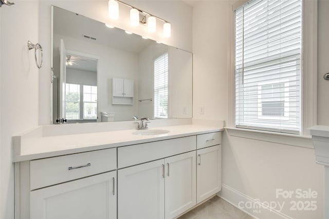 bathroom with a ceiling fan, baseboards, and vanity