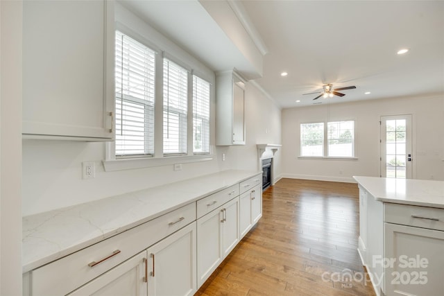 kitchen featuring a ceiling fan, light wood-style flooring, recessed lighting, white cabinets, and light stone countertops