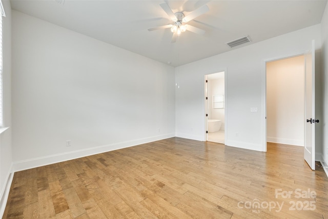 empty room featuring ceiling fan, light wood-style flooring, and baseboards
