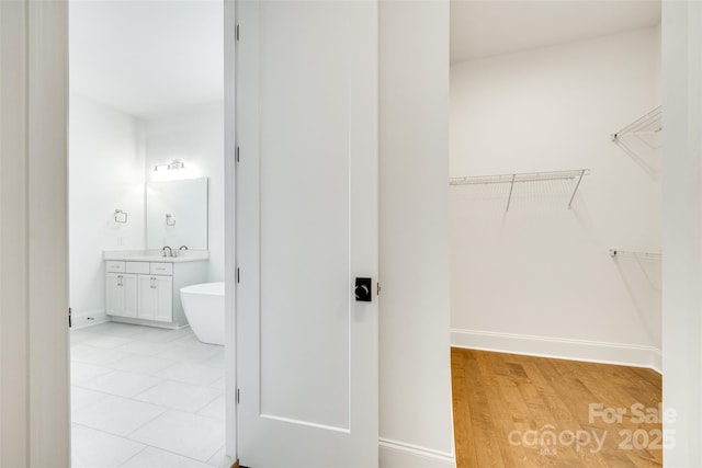 spacious closet with a sink and light wood-style floors