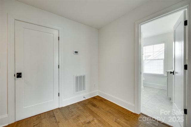 empty room with light wood finished floors and baseboards