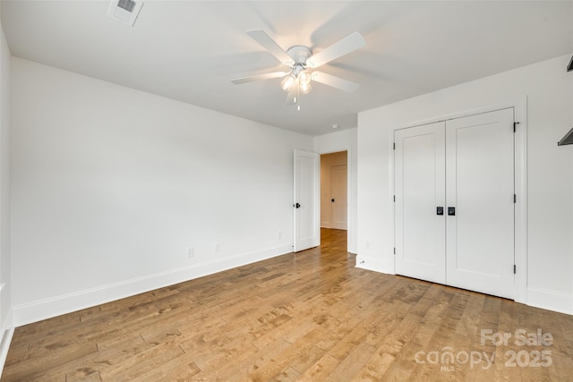 unfurnished bedroom with light wood finished floors, baseboards, a ceiling fan, and a closet