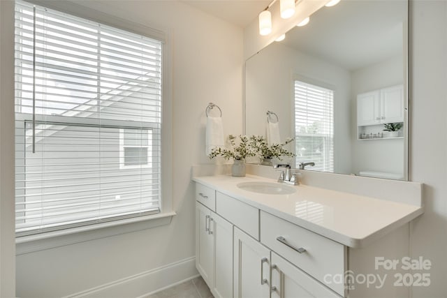 bathroom featuring baseboards, vanity, and tile patterned flooring