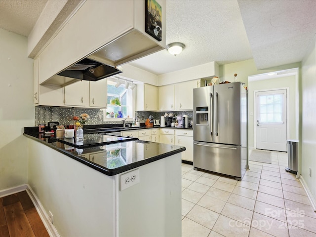 11718 Battery Pl, Charlotte, NC 28273 - kitchen featuring stainless steel fridge, healthy amount of natural light, a peninsula, a textured ceiling, and backsplash