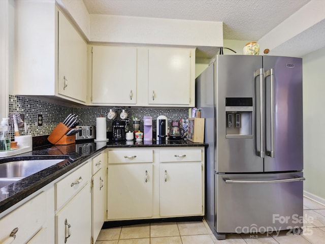 11718 Battery Pl, Charlotte, NC 28273 - kitchen with stainless steel fridge, light tile patterned floors, tasteful backsplash, dark stone counters, and a textured ceiling