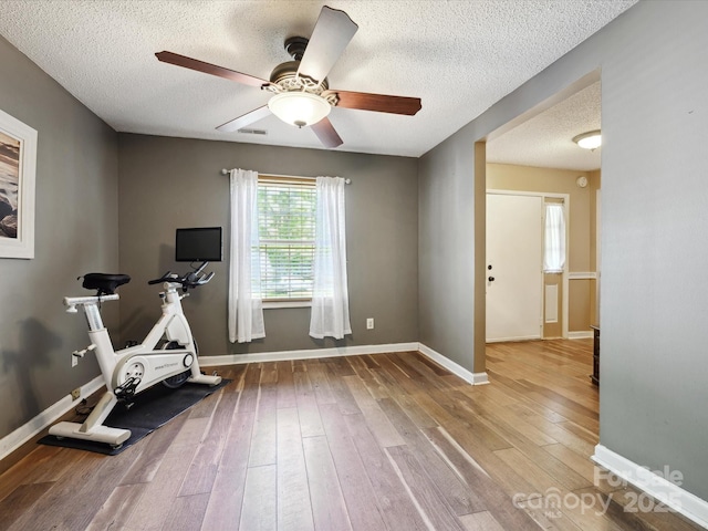 11718 Battery Pl, Charlotte, NC 28273 - workout room with a textured ceiling, a ceiling fan, wood-type flooring, and baseboards
