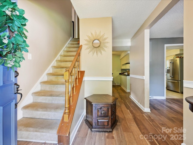 11718 Battery Pl, Charlotte, NC 28273 - foyer with wood-type flooring, stairs, baseboards, and a textured ceiling