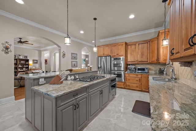 104 Golden Bell Ct, Mooresville, NC 28117 - kitchen featuring stainless steel appliances, arched walkways, a kitchen island, a sink, and light stone countertops