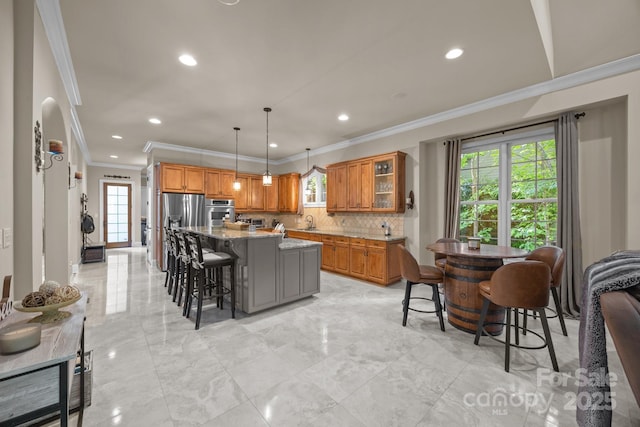 104 Golden Bell Ct, Mooresville, NC 28117 - kitchen featuring ornamental molding, stainless steel appliances, a breakfast bar, light marble finish floors, and backsplash