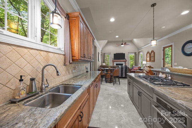 104 Golden Bell Ct, Mooresville, NC 28117 - kitchen featuring a sink, brown cabinets, a ceiling fan, light stone countertops, and stainless steel gas stovetop