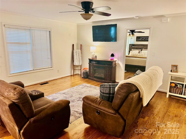 312 Shady Ln, Lincolnton, NC 28092 - living area with ceiling fan, a glass covered fireplace, wood finished floors, baseboards, and ornamental molding