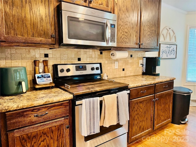 312 Shady Ln, Lincolnton, NC 28092 - kitchen with appliances with stainless steel finishes, ornamental molding, light wood-style floors, backsplash, and light countertops