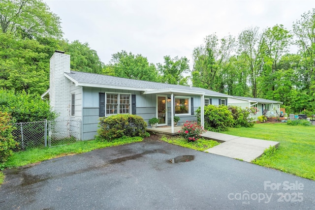 212 Vance Ave, Black Mountain, NC 28711 - ranch-style house with a chimney, covered porch, a shingled roof, and view of wooded area