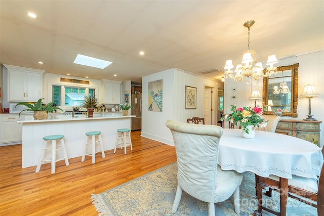 212 Vance Ave, Black Mountain, NC 28711 - dining area with a chandelier, light wood-type flooring, a skylight, and recessed lighting