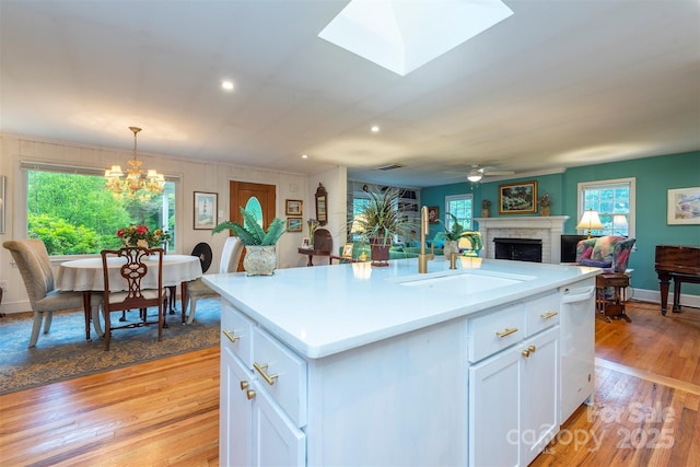 212 Vance Ave, Black Mountain, NC 28711 - kitchen featuring a sink, a fireplace, light countertops, a chandelier, and white cabinetry
