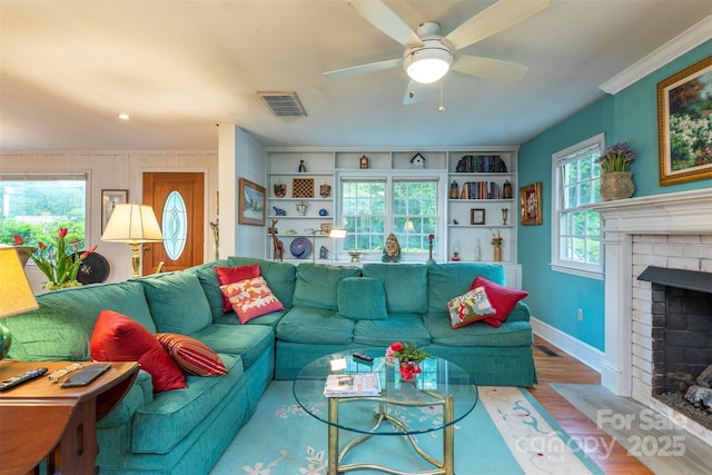 212 Vance Ave, Black Mountain, NC 28711 - living area featuring a brick fireplace, wood finished floors, baseboards, ceiling fan, and crown molding